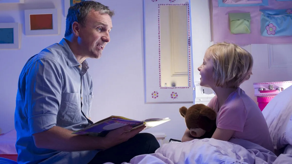 Dad reading to a daughter in bed