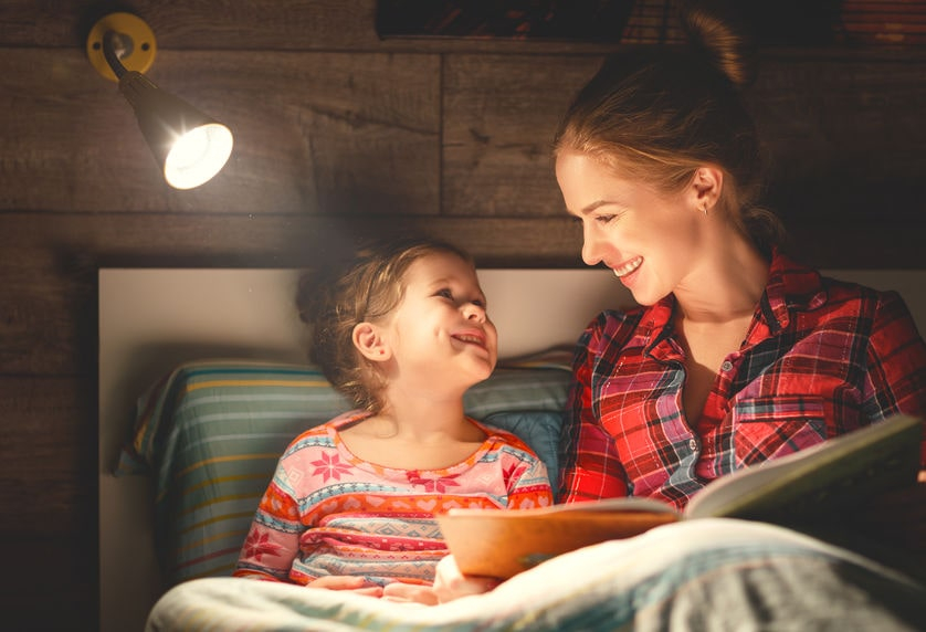 Mom and daughter reading in bed