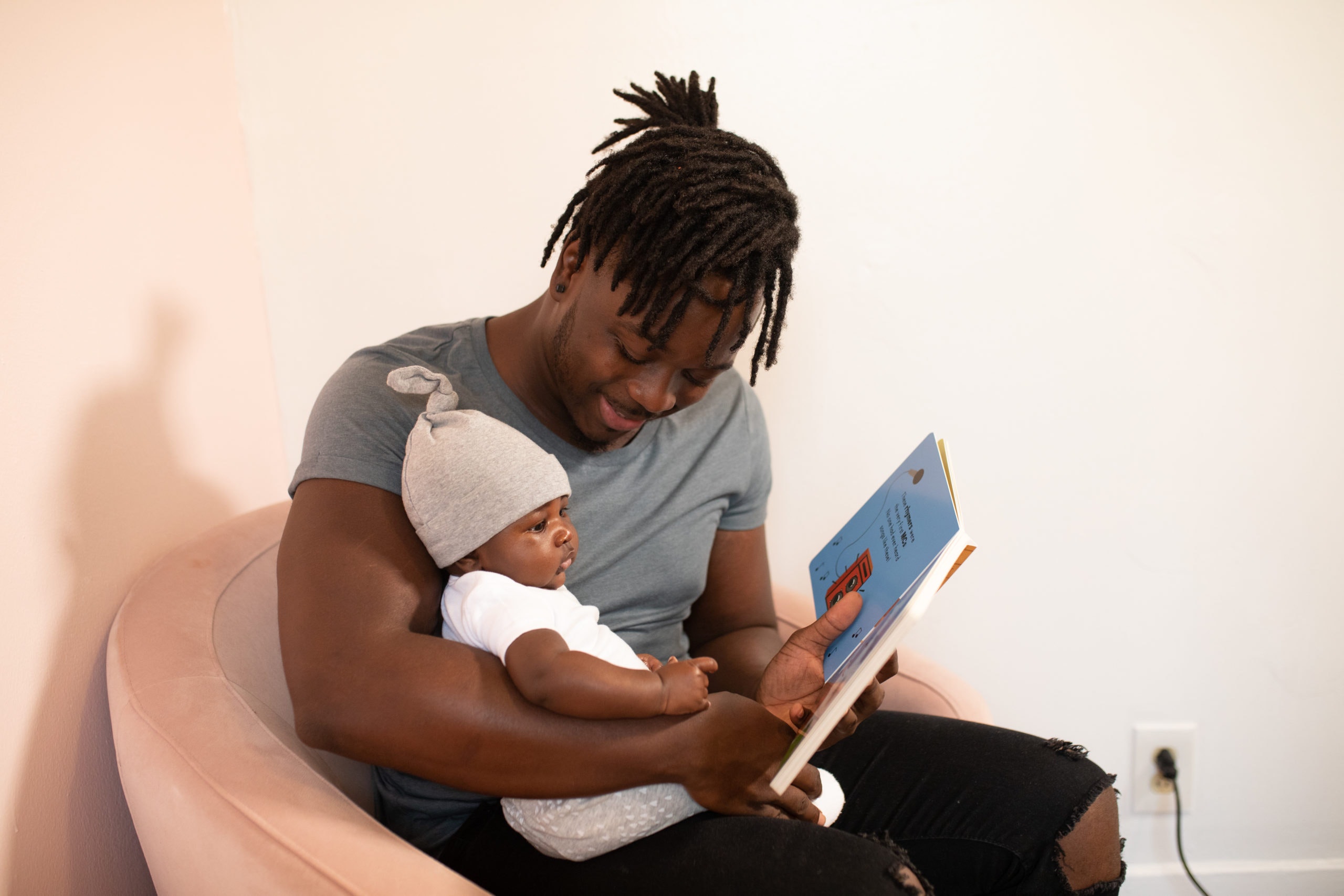Dad is reading a book with little one