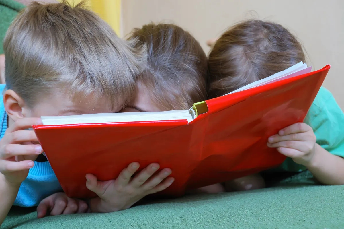 Three kids are very into the book